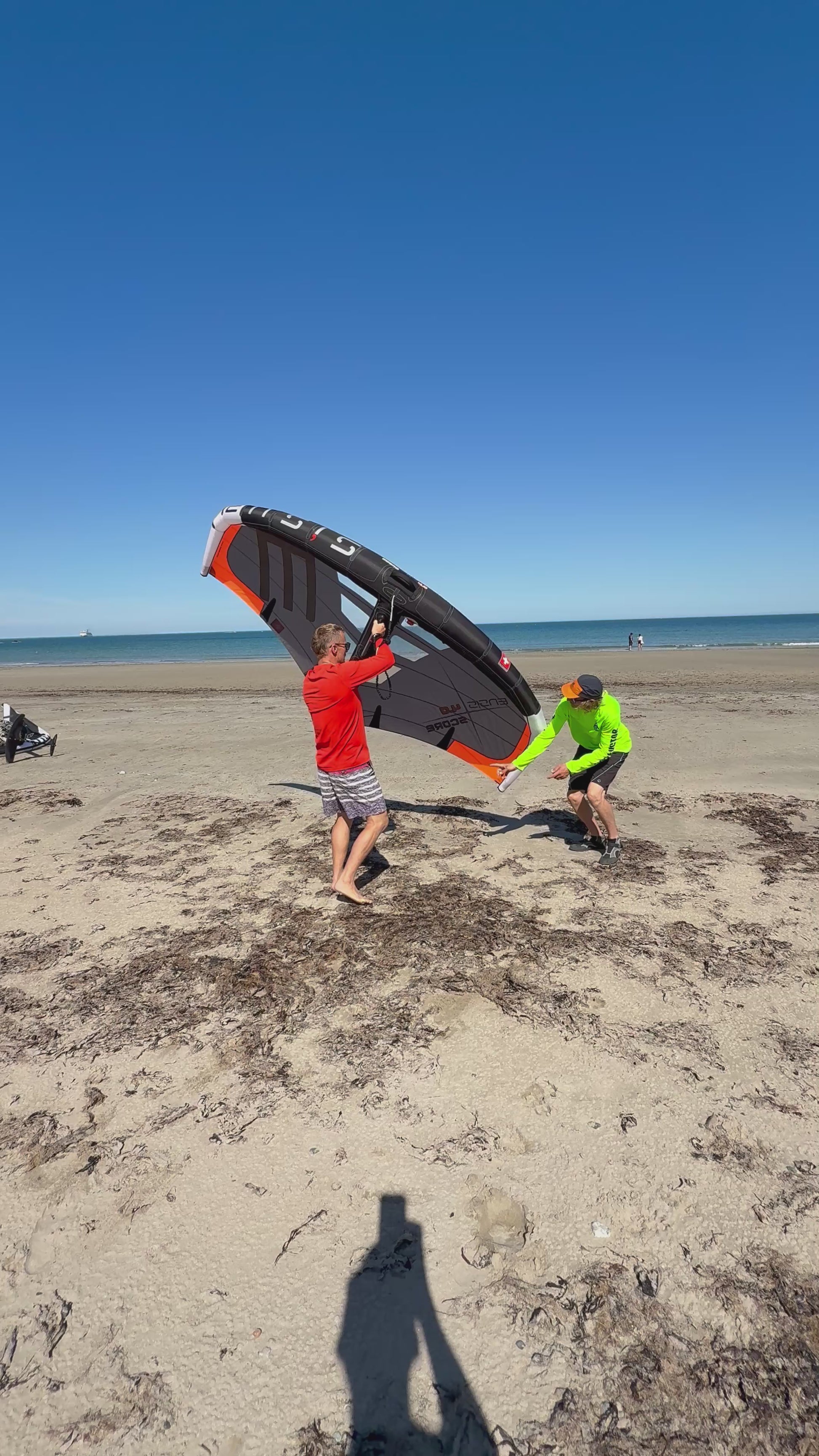Surf Summit instructor with students teaching Wing handling on beach North Wales Crystal Clearwater